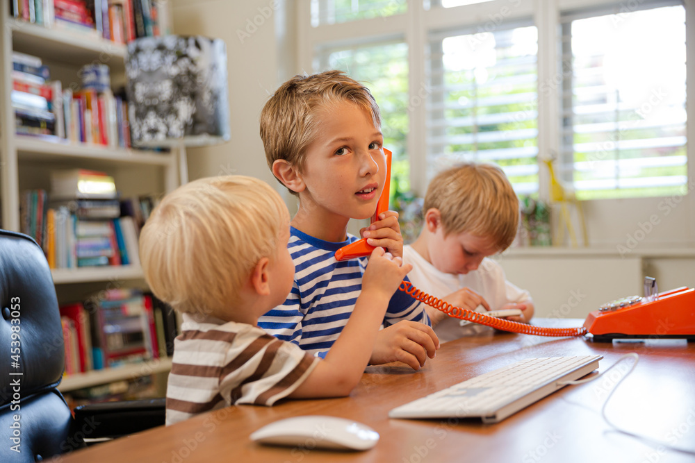 Boys using telephone in home office Boys using telephone in home office