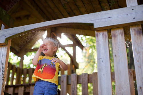 Boy playing on playset outdoors © KOTO