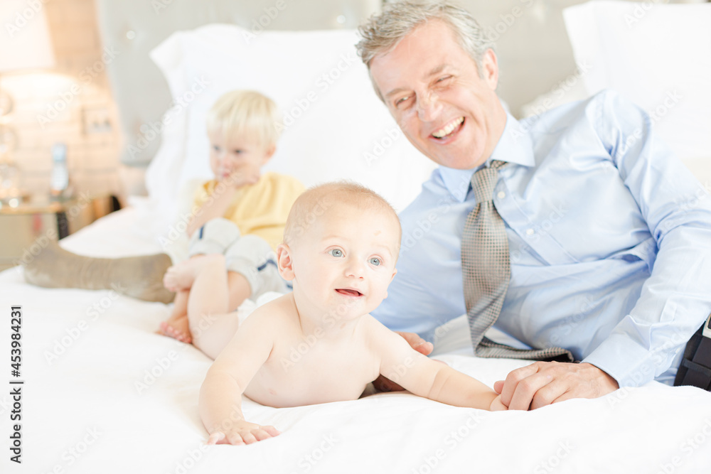 Father and children relaxing on bed