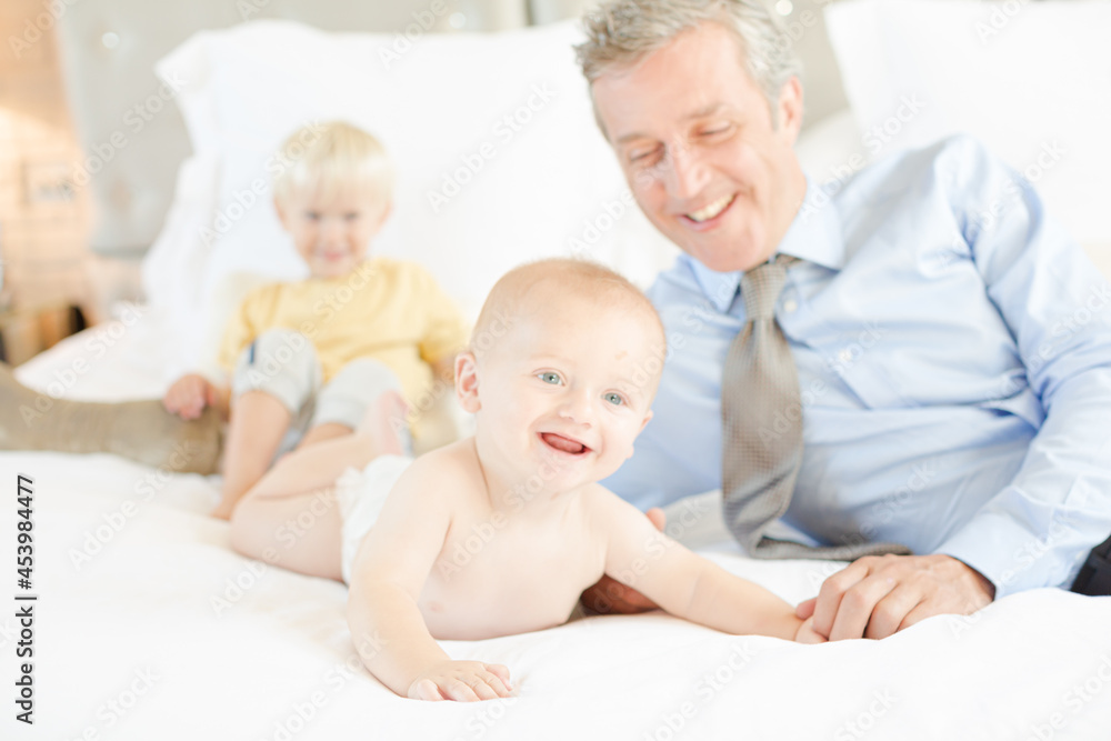 Father and children relaxing on bed