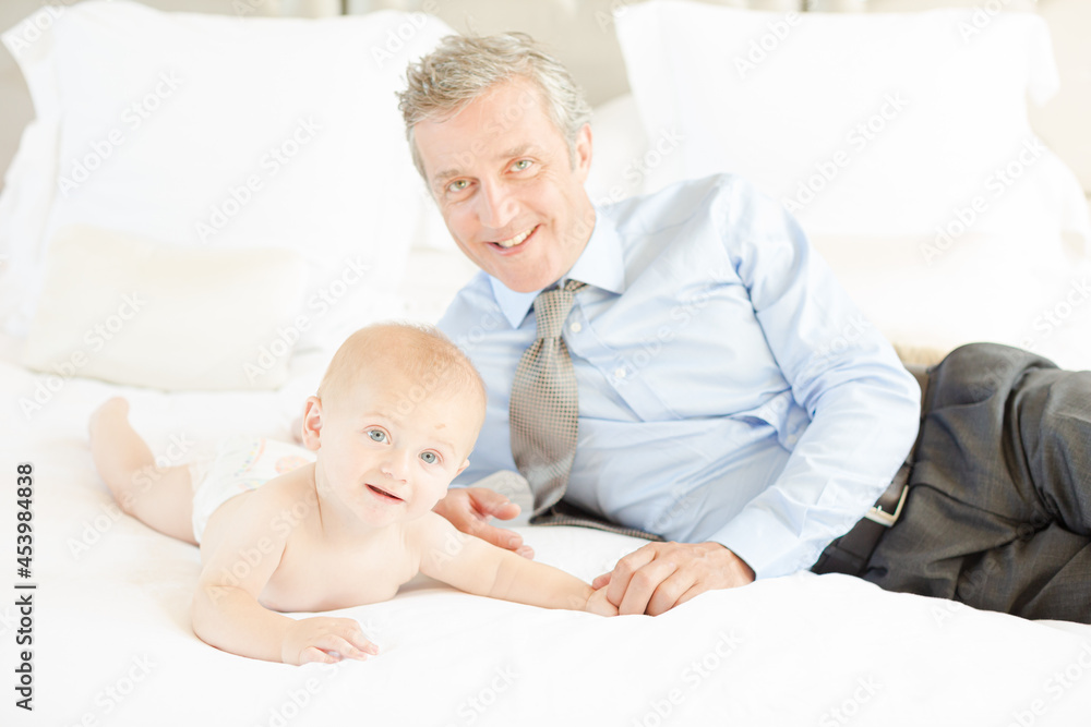 Father laying with baby on bed Father laying with baby on bed