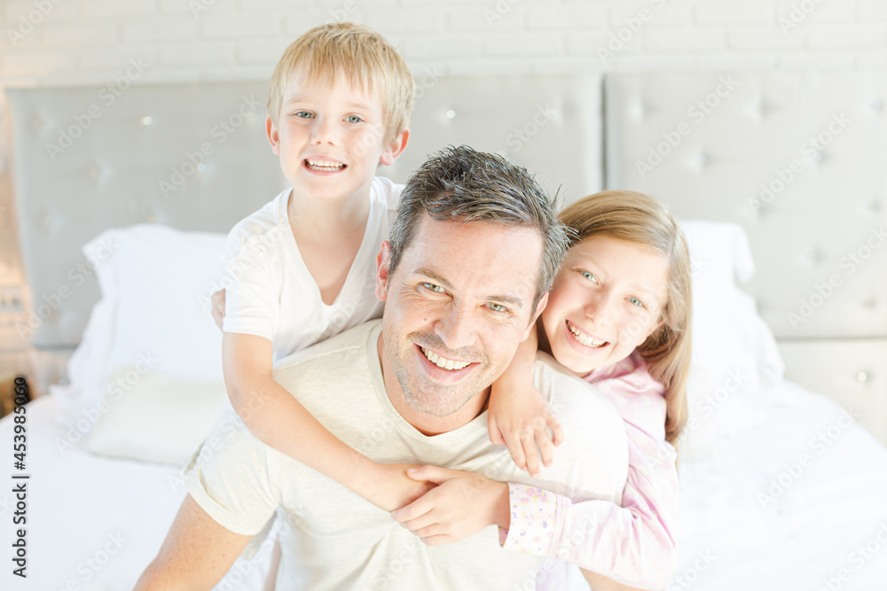 Father and children hugging in bedroom Father and children hugging in bedroom