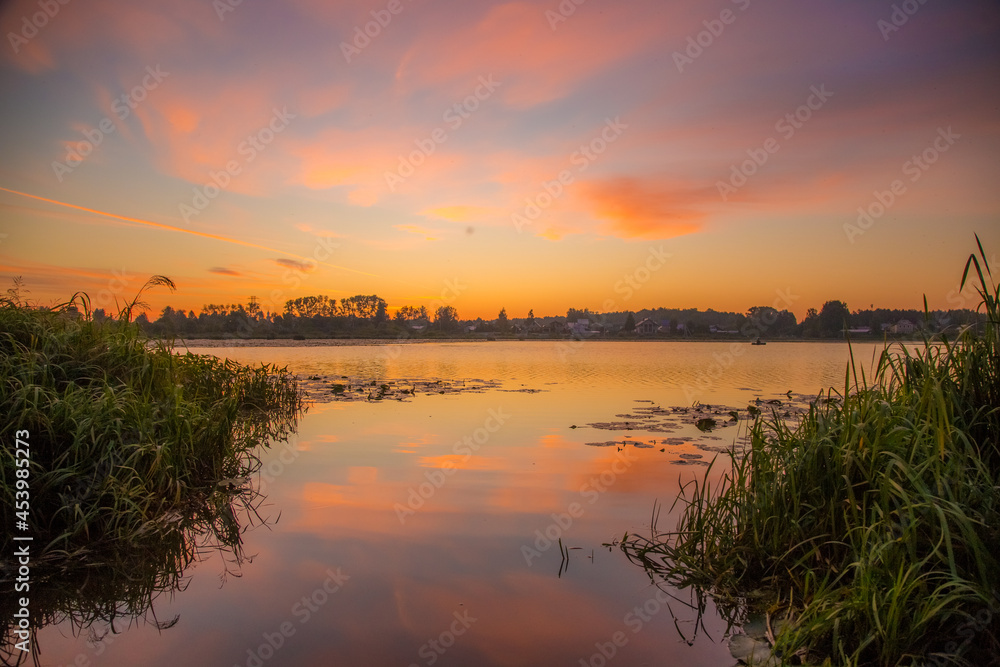 beautiful landscape of the water surface of the lake on a summer morning with light clouds in the sky reflecting in the water