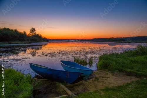 fishermen's boats are laid up at dawn on a clear summer morning