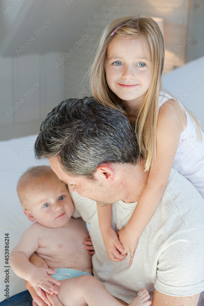 Father and children hugging in bedroom Father and children hugging in bedroom