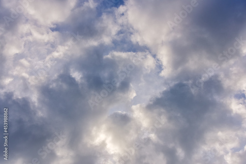 blue sky background with cumulus white clouds and looming storm clouds