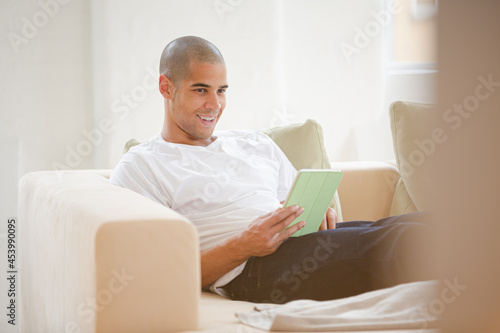 Man using digital tablet on sofa