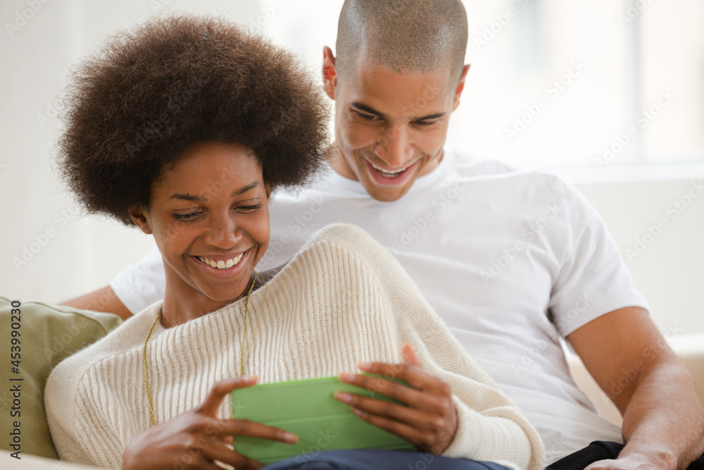 Couple using digital tablet on sofa Couple using digital tablet on sofa