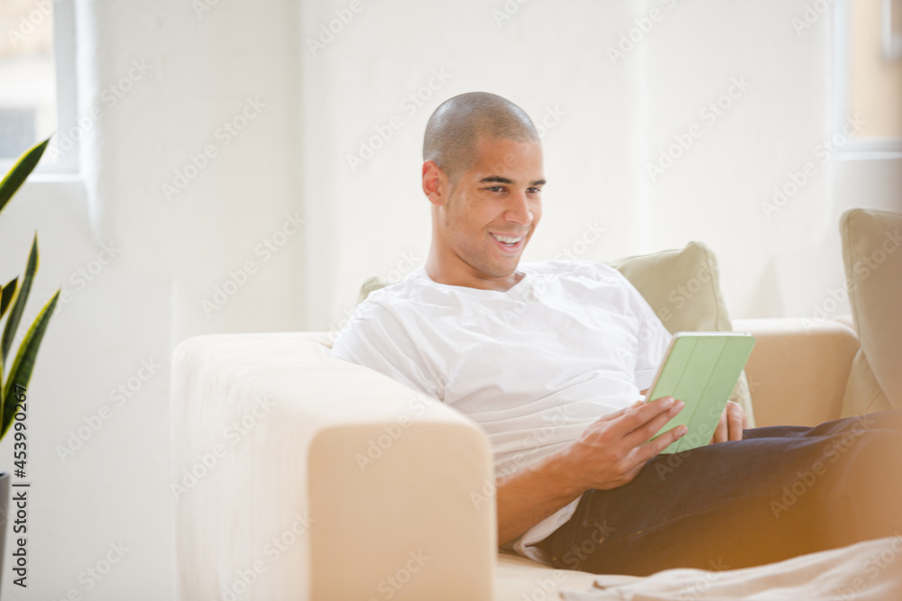 Man using digital tablet on sofa Man using digital tablet on sofa