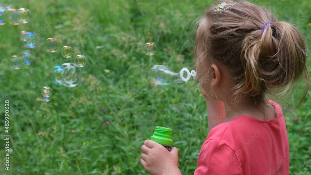 Little girl blowing soap bubbles . Active child walking in the park. Family lifestyle, outdoors activities, summer holidays with kids. Little girl blowing soap bubbles . Active child walking in the park. Family lifestyle, outdoors activities, summer holidays with kids.