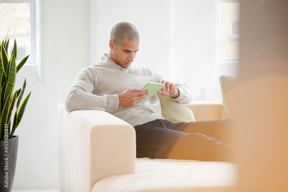 Man using digital tablet on sofa Man using digital tablet on sofa