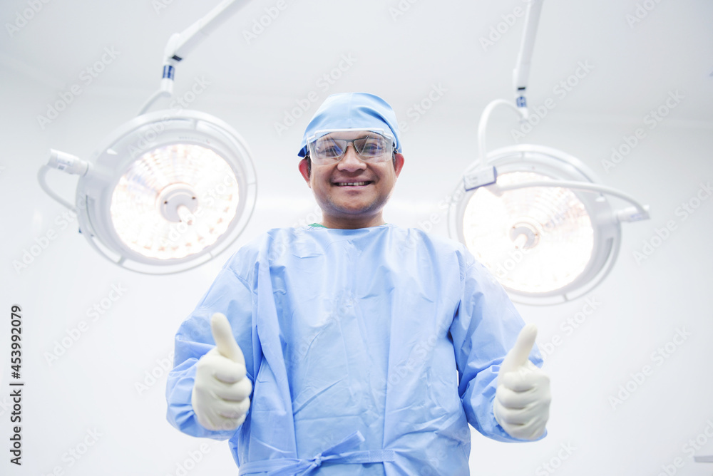 Naklejka premium Asian surgeon ,operating room at the hospital The surgeon team is performing the surgery. A middle-aged doctor looks at a camera in a modern operating room.
