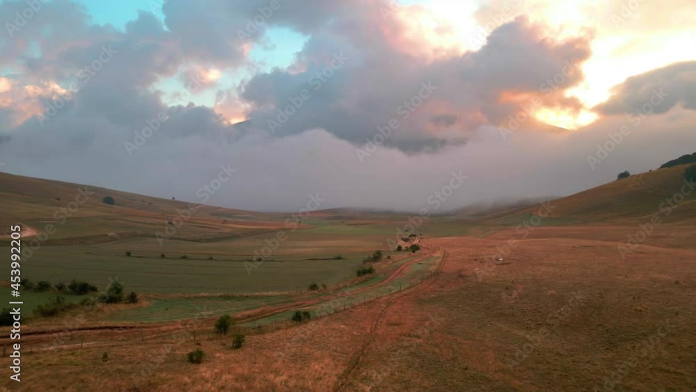 Drone Flying Over Peasants Fields During Sunrise With Fluffy Clouds And Fog In The Sky In Tuscany, Italy. - aerial Drone Flying Over Peasants Fields During Sunrise With Fluffy Clouds And Fog In The Sky In Tuscany, Italy. - aerial
