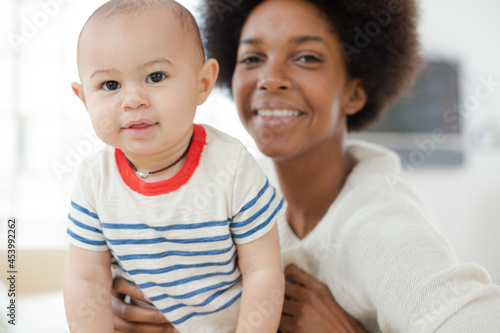 Mother holding baby boy on sofa