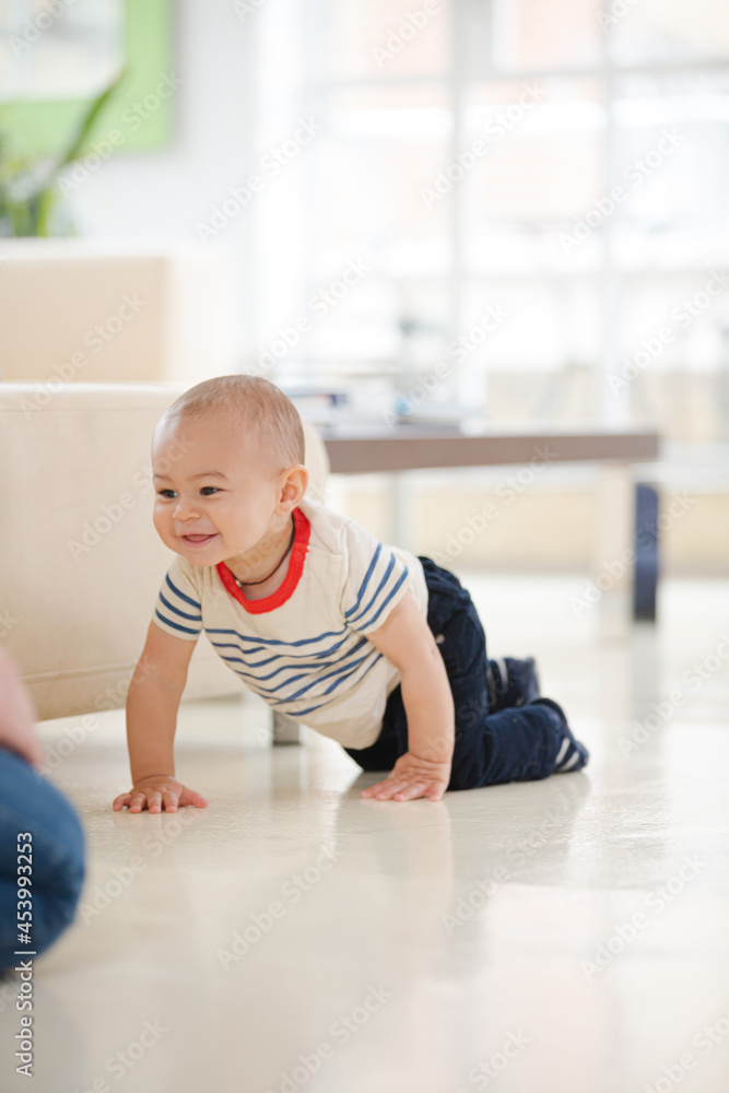 Baby boy crawling on living room floor Baby boy crawling on living room floor