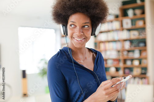 Woman listening to headphones in living room