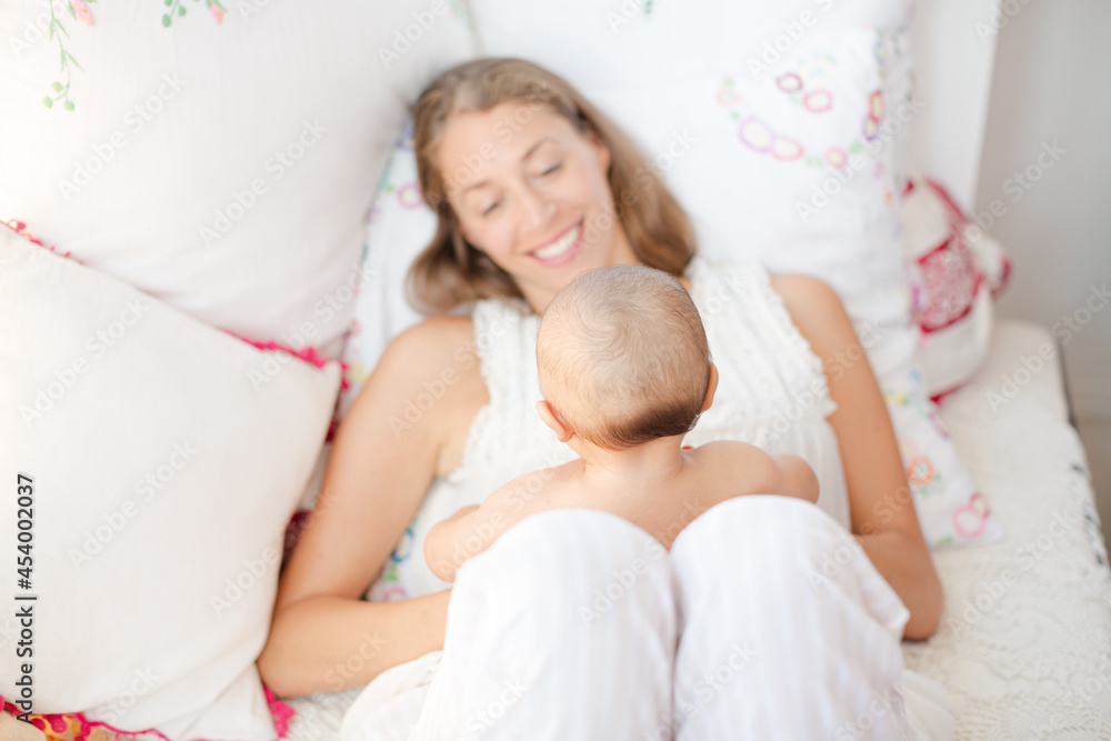 Mother holding baby boy on bed Mother holding baby boy on bed
