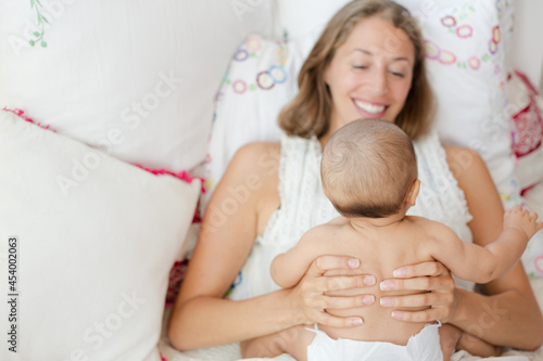 Mother holding baby boy on bed