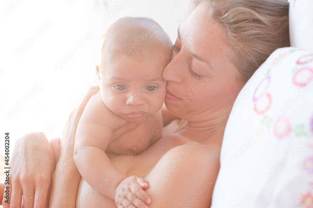 Mother holding baby boy on bed Mother holding baby boy on bed