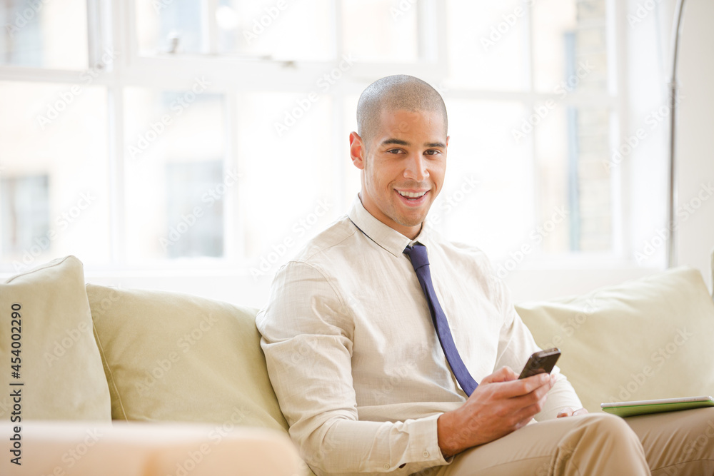 Businessman using cell phone on sofa Businessman using cell phone on sofa