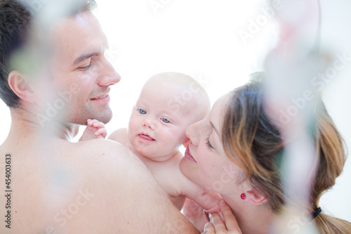 Parents kissing baby girl's cheeks