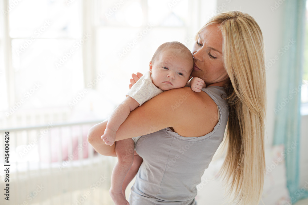 Mother holding baby girl in nursery Mother holding baby girl in nursery