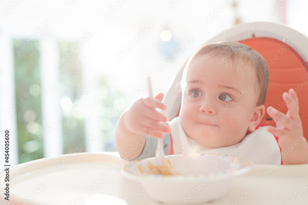 Baby boy eating in high chair