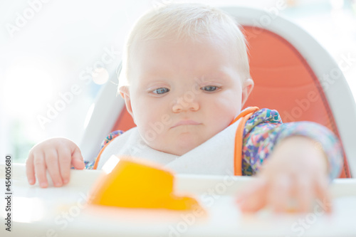 Baby girl playing with gelatin dessert in high chair