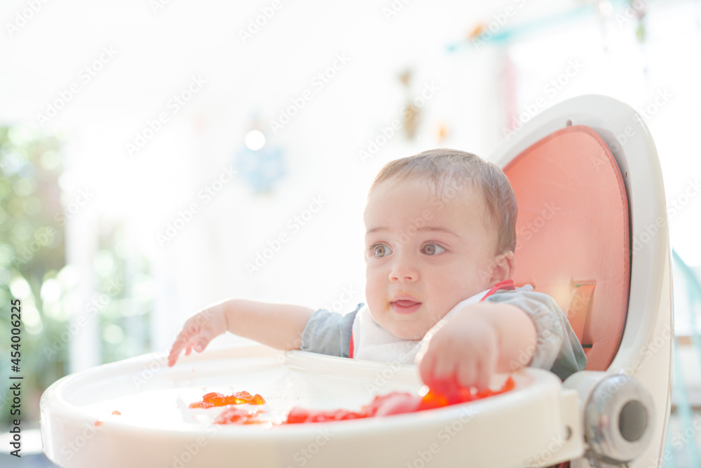 Baby boy eating gelatin dessert in high chair Baby boy eating gelatin dessert in high chair