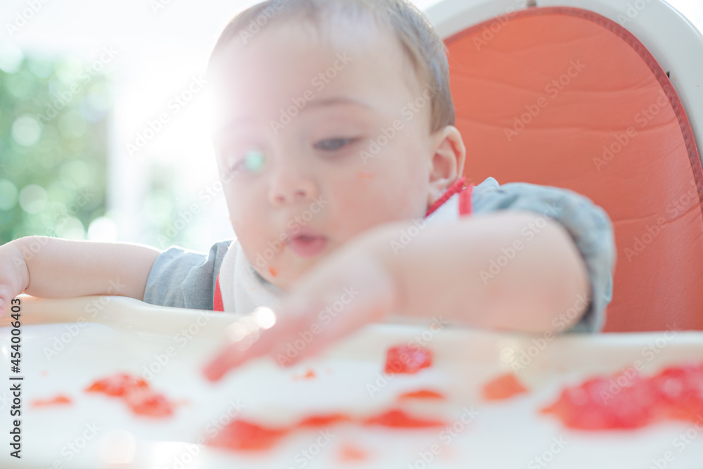 Baby boy eating gelatin dessert in high chair Baby boy eating gelatin dessert in high chair