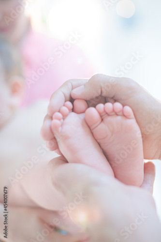Father cradling baby boy's feet © KOTO