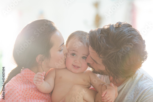 Parents kissing baby boy's cheeks