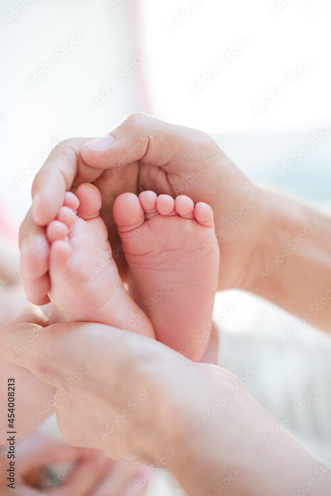 Father cradling baby boy's feet Father cradling baby boy's feet