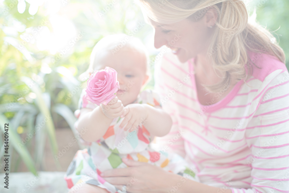 Mother and baby girl playing with flower Mother and baby girl playing with flower