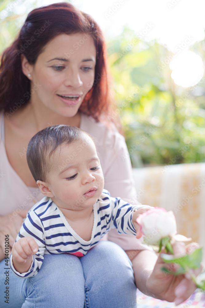 Mother and baby girl playing with flower Mother and baby girl playing with flower