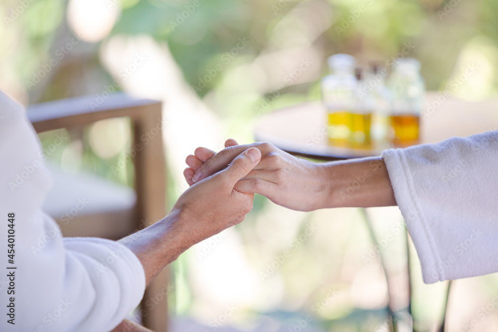 Couple in bathrobes holding hands in spa Couple in bathrobes holding hands in spa