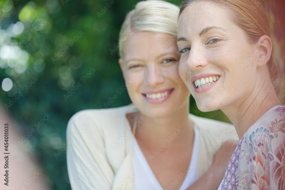 Women smiling together outdoors Women smiling together outdoors