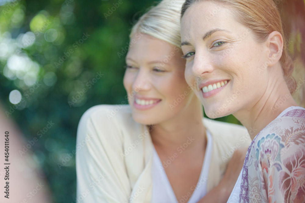 Women smiling together outdoors Women smiling together outdoors