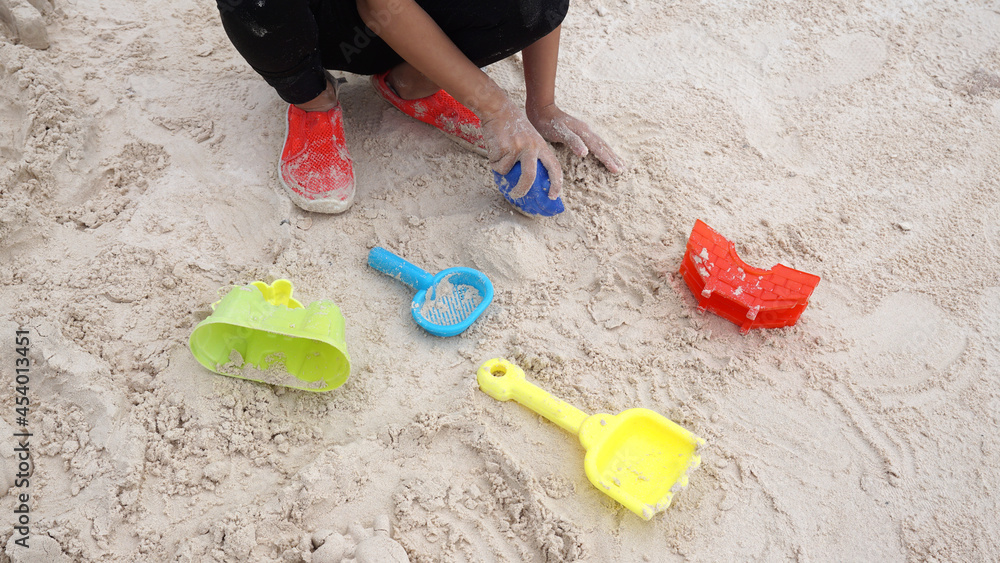Kid hands with colorful toy on the beach Kid hands with colorful toy on the beach