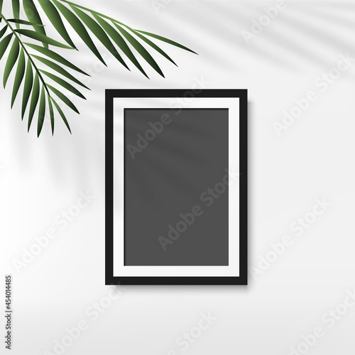 Black photo frame with palm leaves in white background. Vector
