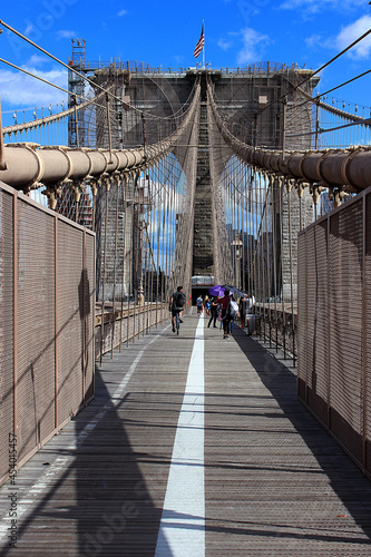 Brooklyn Bridge in New York, USA. People walk along the famous Brooklyn Bridge. © Vered Ateer