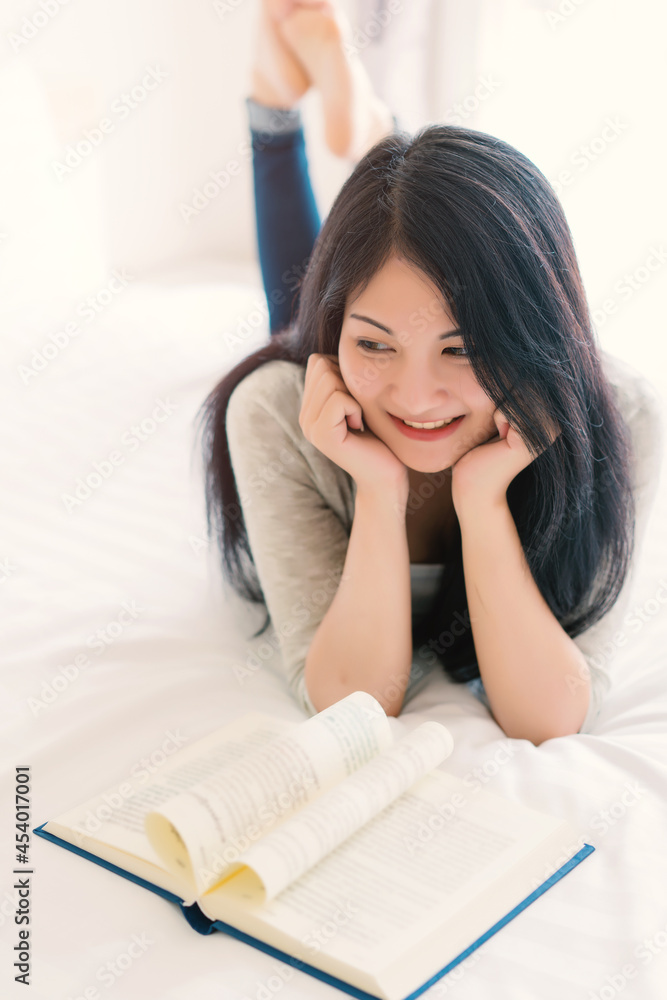 Young beautiful woman reading a book on bed at home, education, reading for examination, favourite literature, busy day concept Young beautiful woman reading a book on bed at home, education, reading for examination, favourite literature, busy day concept
