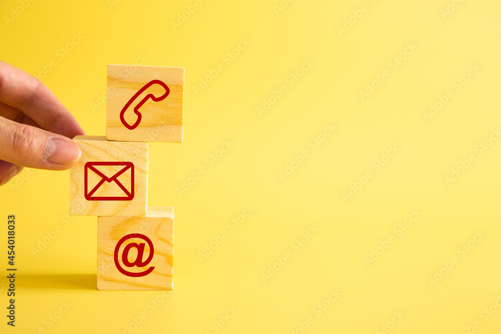 Businessman hand putting wooden block cube symbol telephone, email, address. Businessman hand putting wooden block cube symbol telephone, email, address.