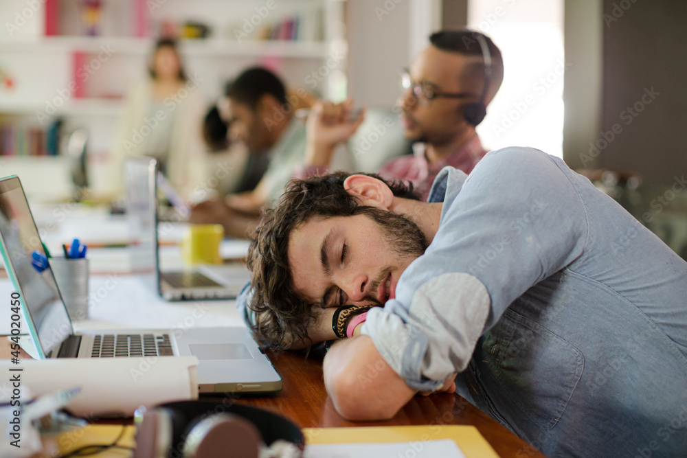 Man sleeping at desk in office Man sleeping at desk in office