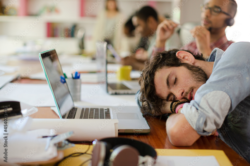 Man sleeping at desk in office Man sleeping at desk in office