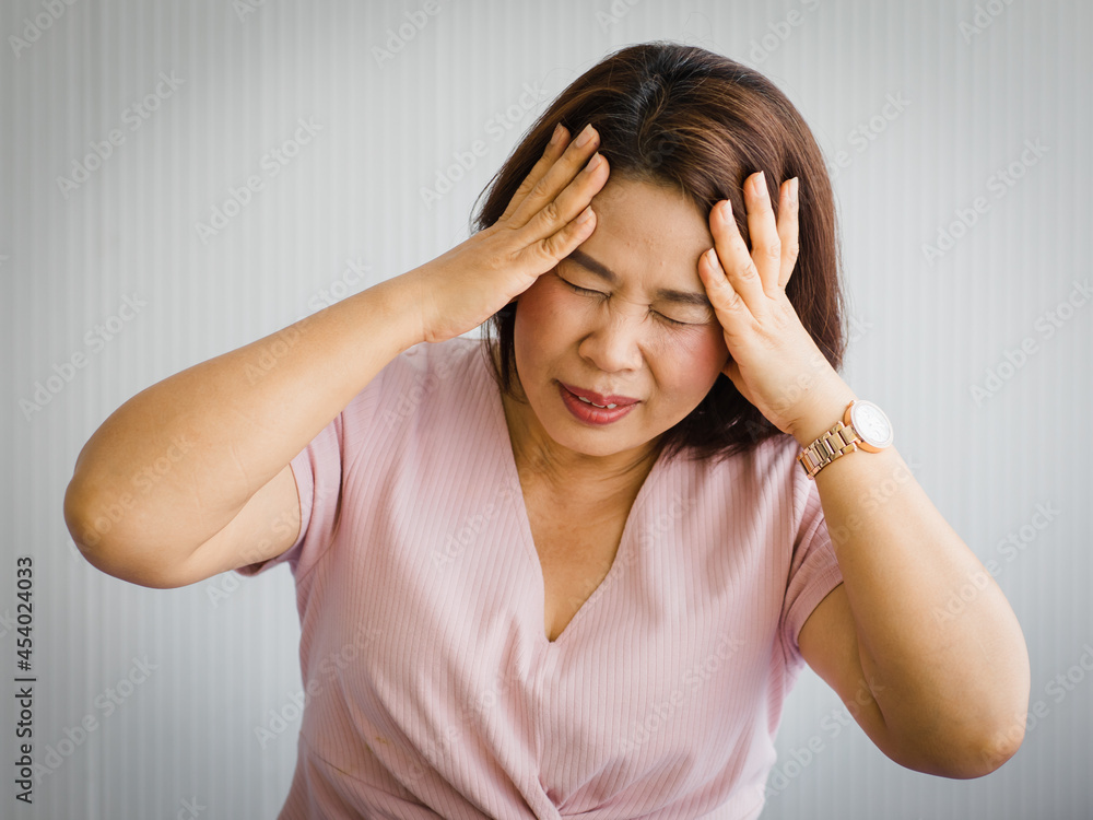 Middle age senior Asian woman feeling pain from sudden headache and brain stroke attack and hold her head with a stressed face. Concept of brain and head problem Middle age senior Asian woman feeling pain from sudden headache and brain stroke attack and hold her head with a stressed face. Concept of brain and head problem