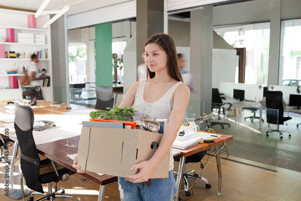 Woman carrying cardboard box in office Woman carrying cardboard box in office