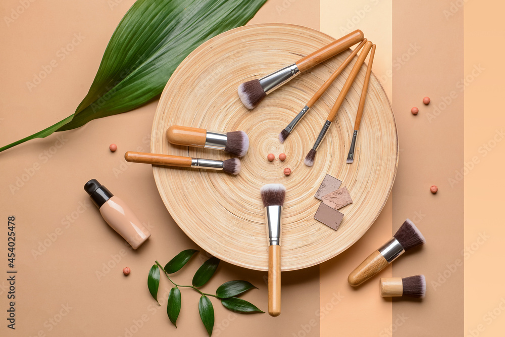 Naklejka premium Set of makeup brushes with decorative cosmetics on color background