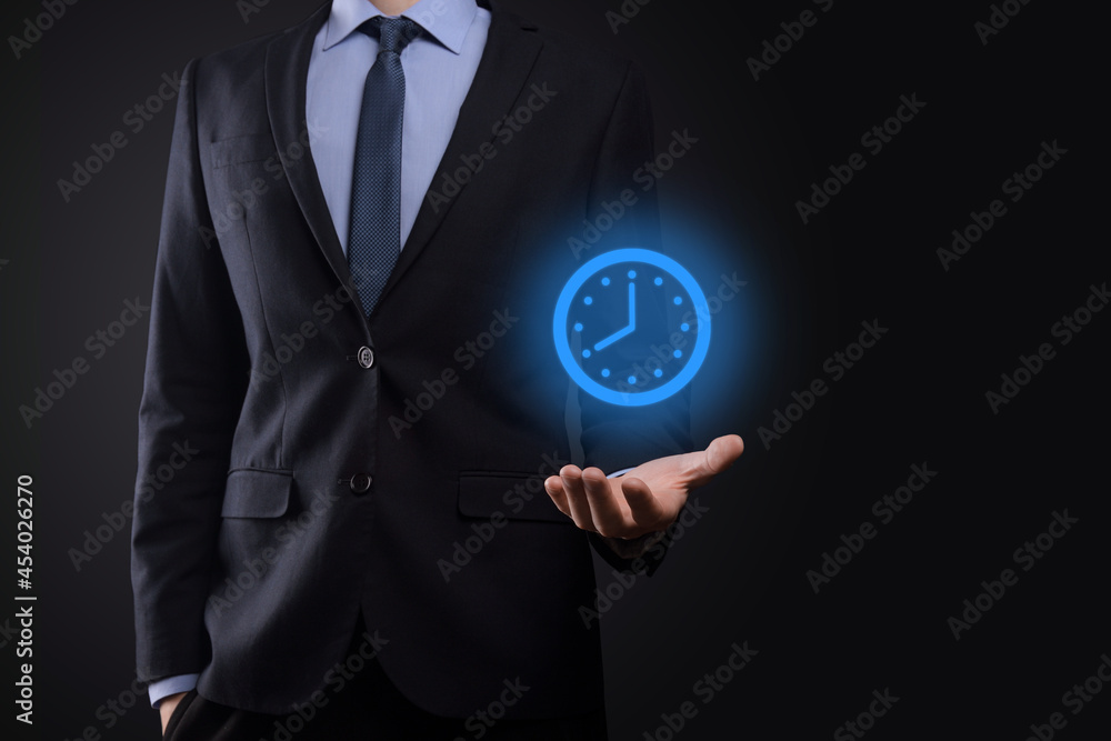 Businessman hand holds the icon of hours clock with arrow. Rapid execution of the work.Business time management and business time is money concepts Businessman hand holds the icon of hours clock with arrow. Rapid execution of the work.Business time management and business time is money concepts
