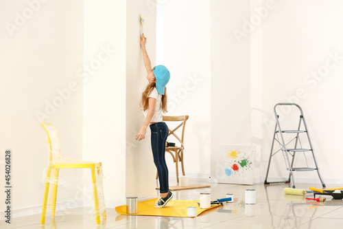 Little girl painting wall i...
